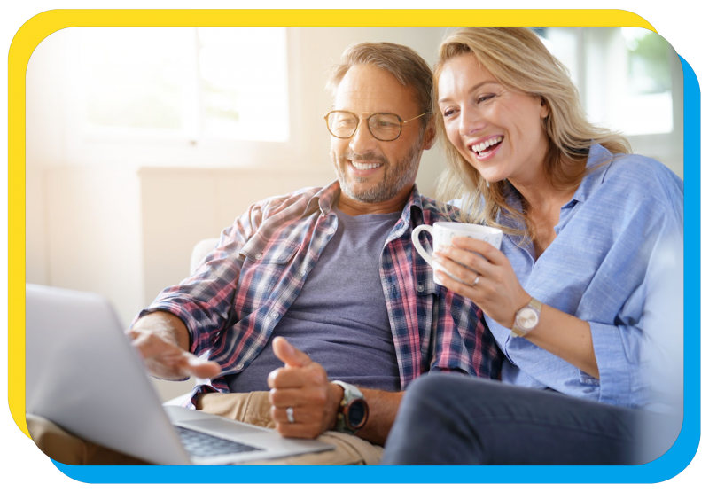 couple with coffee smiling at laptop
